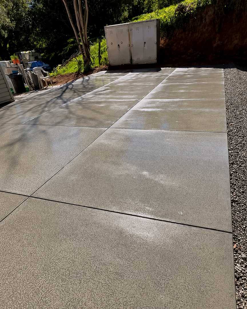 Newly poured concrete driveway with control joints and compacted gravel border