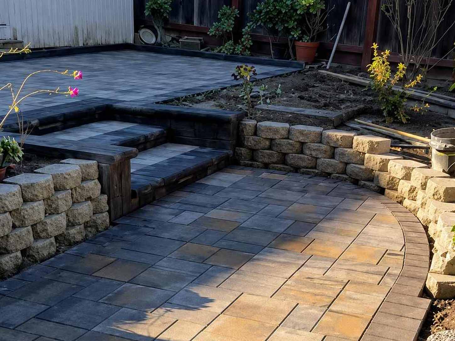 Curved paver patio with steps and stone retaining walls